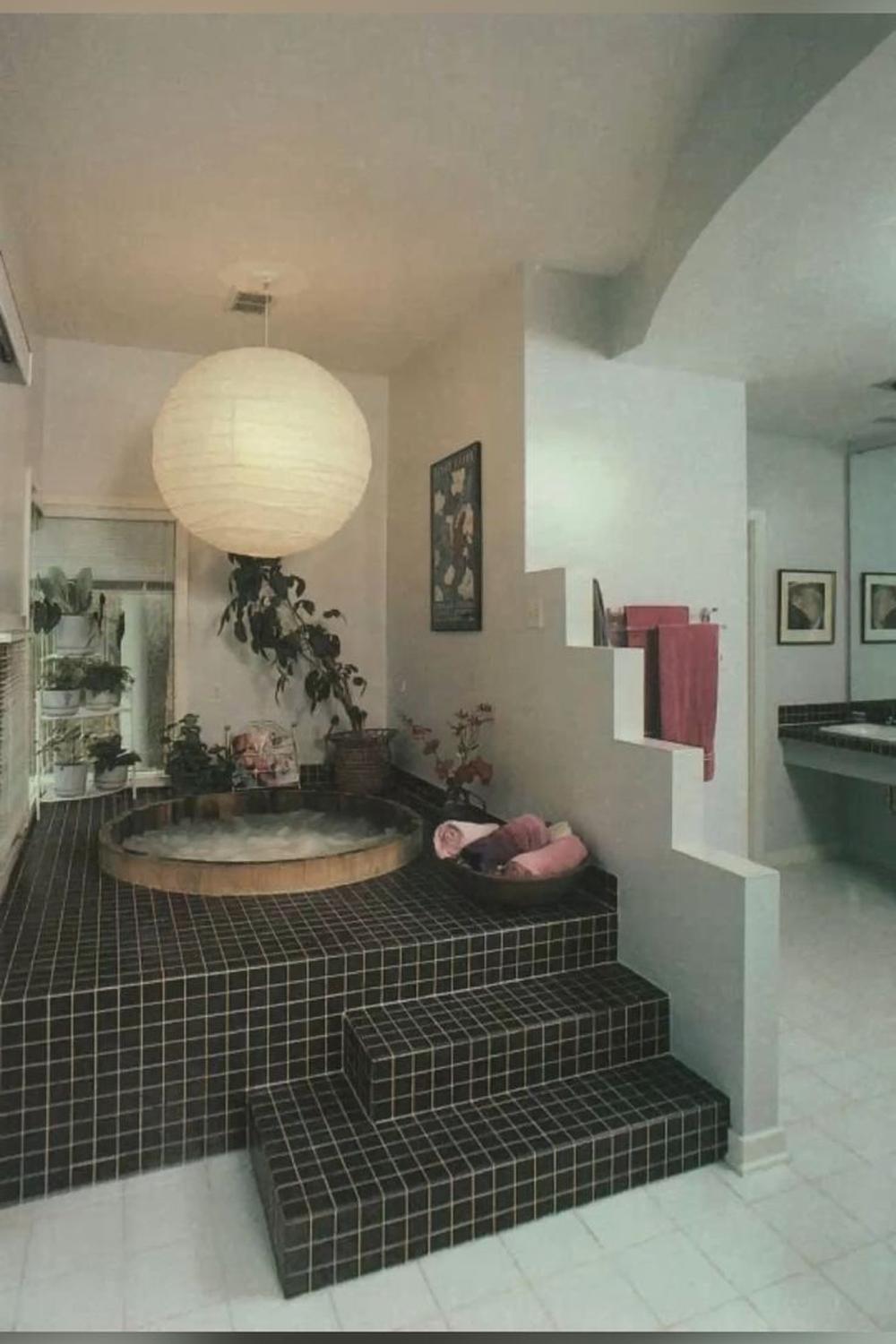 A distinct bathroom featuring a unique multi-level design centered around a circular hot tub.