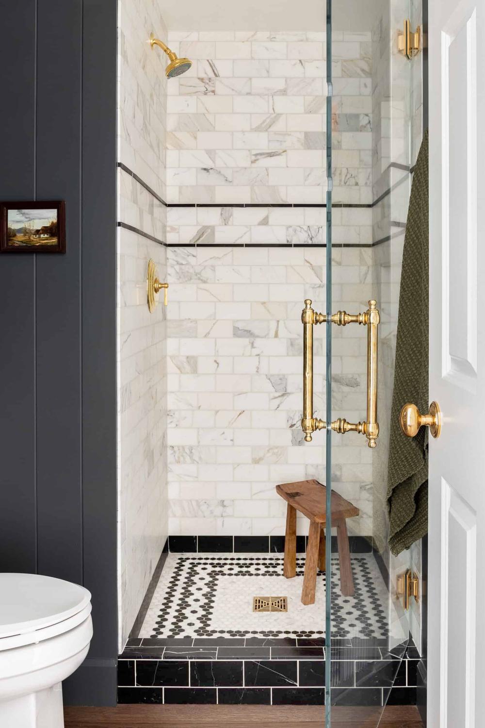 Elegant gold fixtures paired with intricate geometric patterns in a stylish shower.