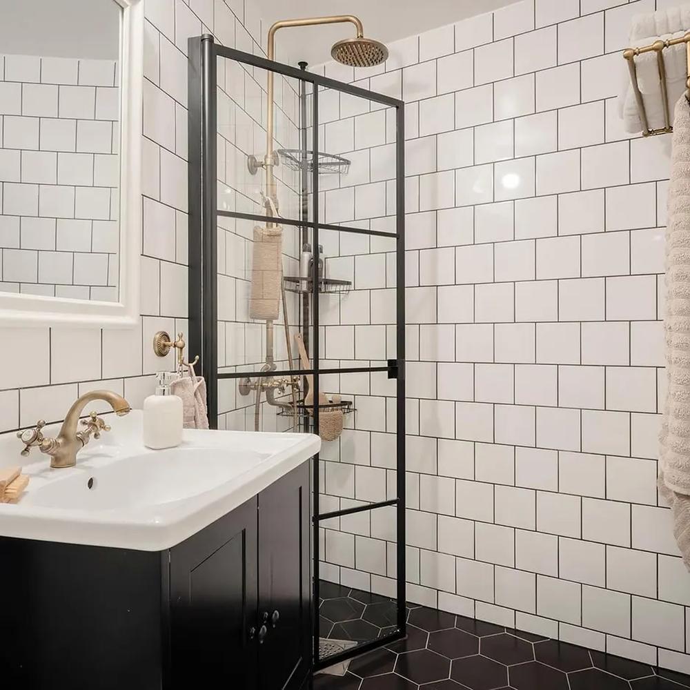 A stylish bathroom with delicate black hexagonal tiles, chic decorative accessories, and a harmonious balance of black and white design elements.