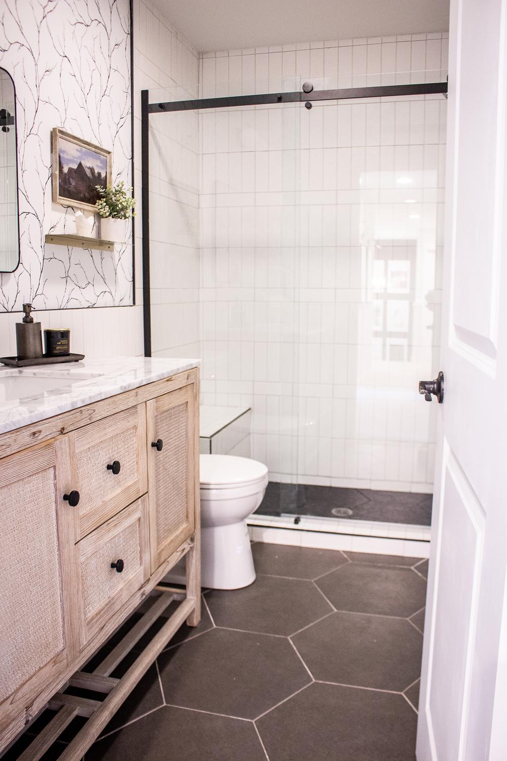 A contemporary bathroom defined by an elegant balance of white surfaces, black accents, and subtle wood tones for a minimalist yet inviting design.