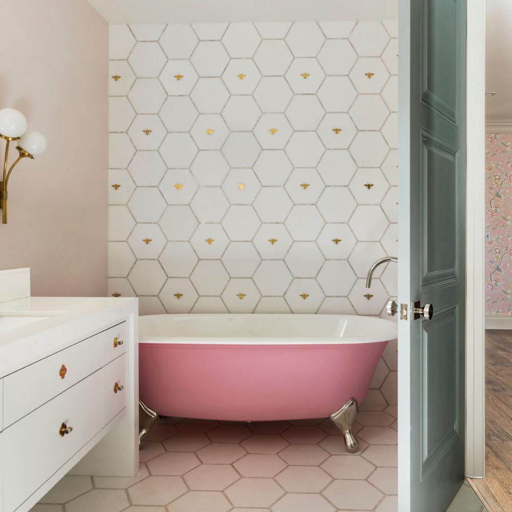 Baño moderno con acento de azulejos hexagonales blancos con detalles dorados.