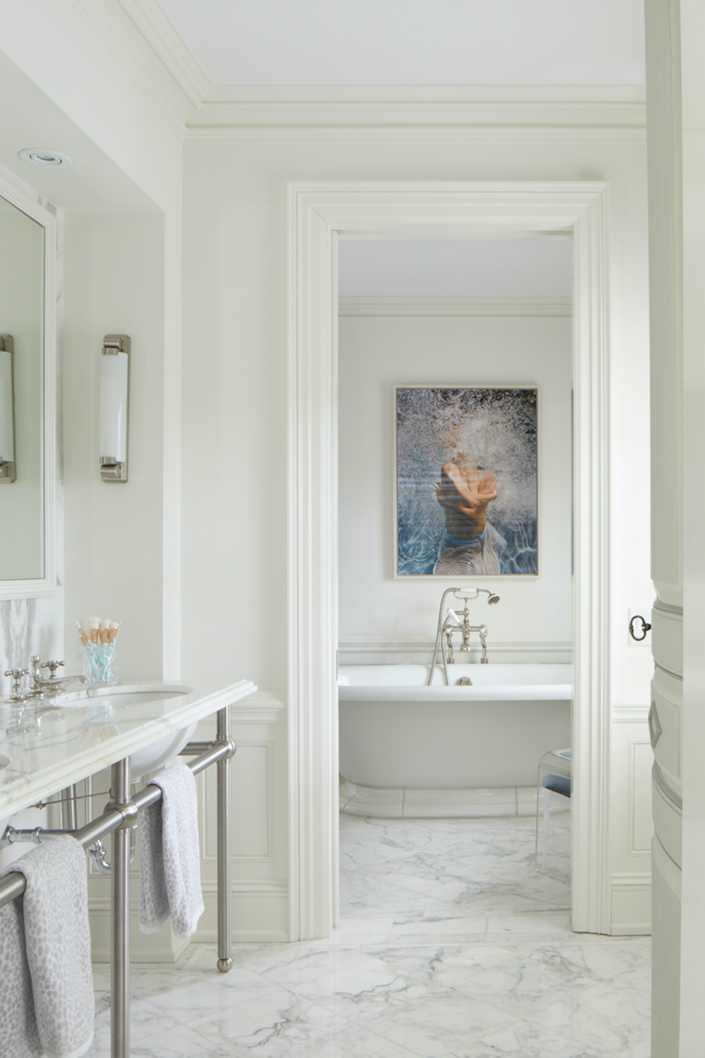 Baño elegante con mármol y lámparas de pared