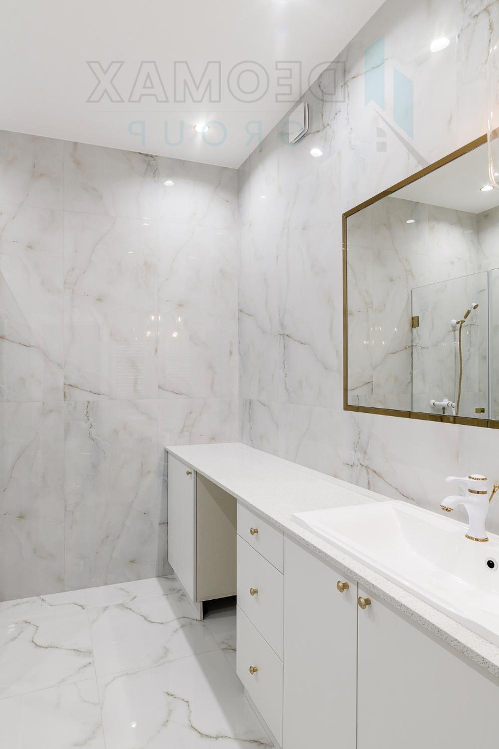 Opulent all-white bathroom featuring luxurious marble and polished fixtures.