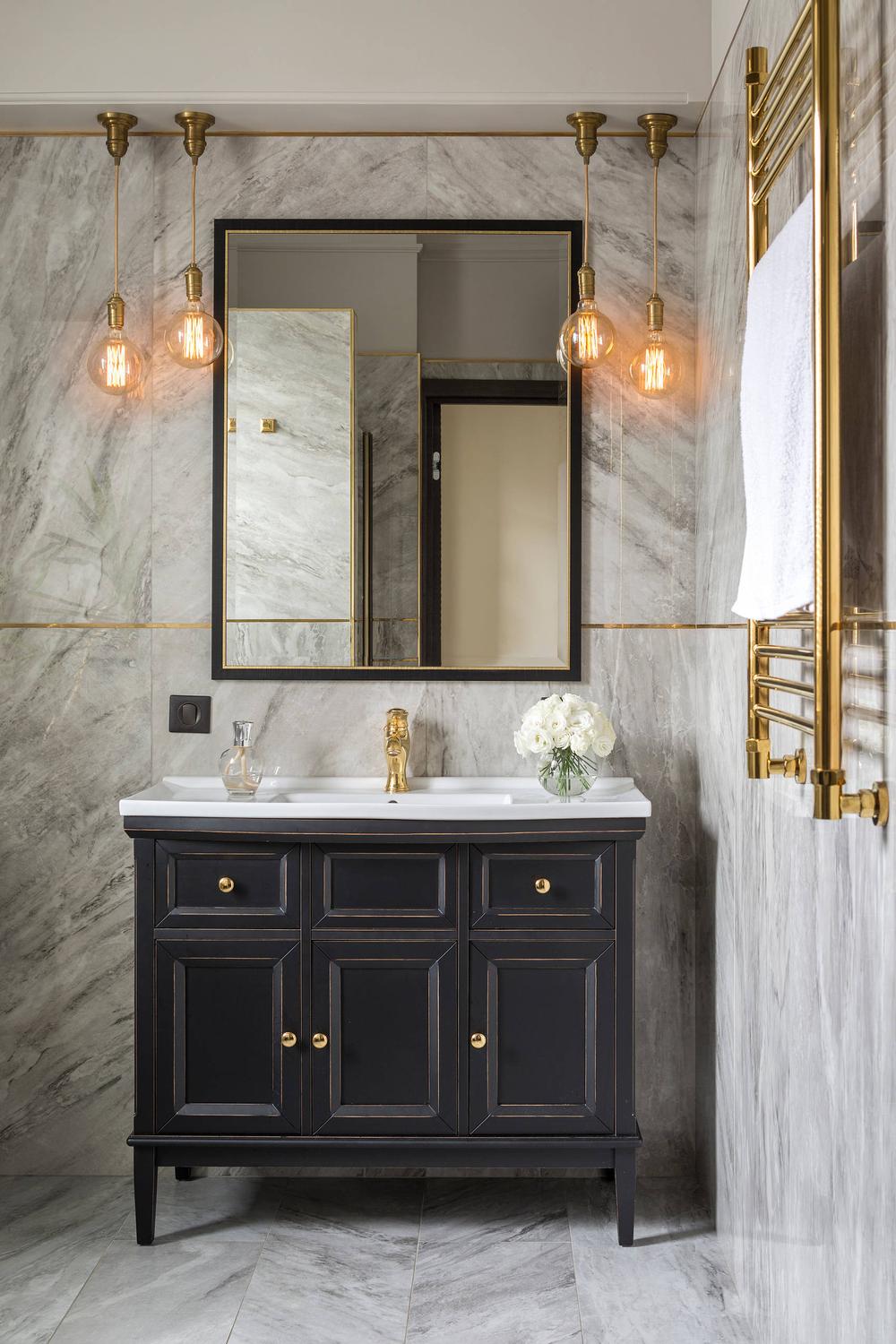 An elegant American farmhouse bathroom with a polished white countertop and a stylish black cabinet vanity.