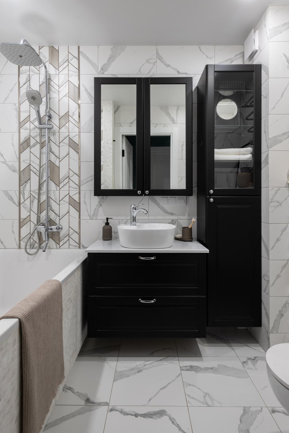 Stylish American farmhouse bathroom featuring sleek black cabinets and a double-mirror cabinet.