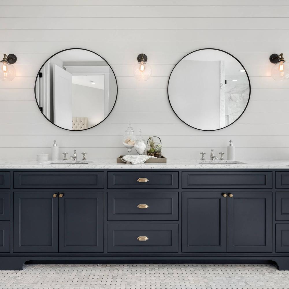 Stylish American farmhouse bathroom with dark cabinets and textured patterns.