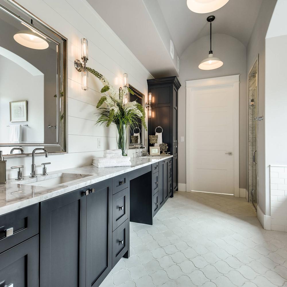 Stylish American farmhouse bathroom blending modern vintage charm with wood and black cabinetry.