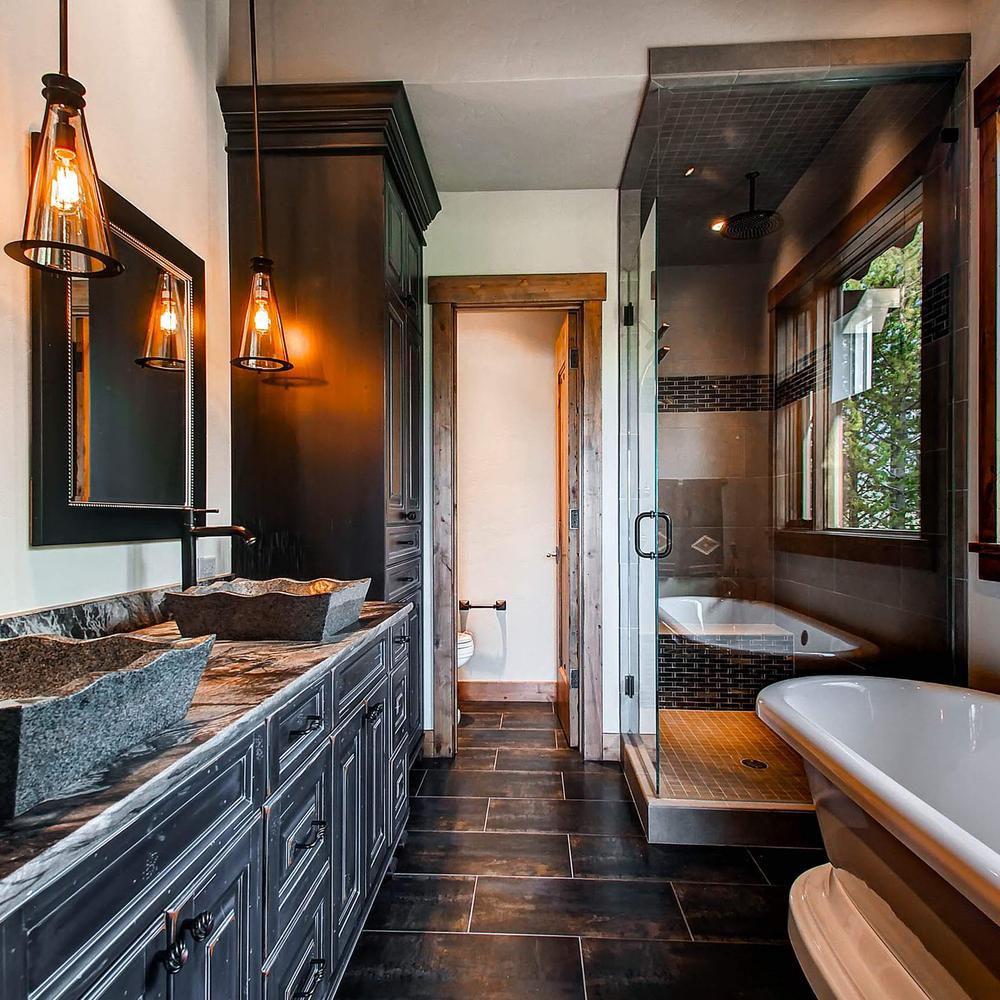 American farmhouse bathroom with thoughtful design showcasing visual interest and black cabinetry.