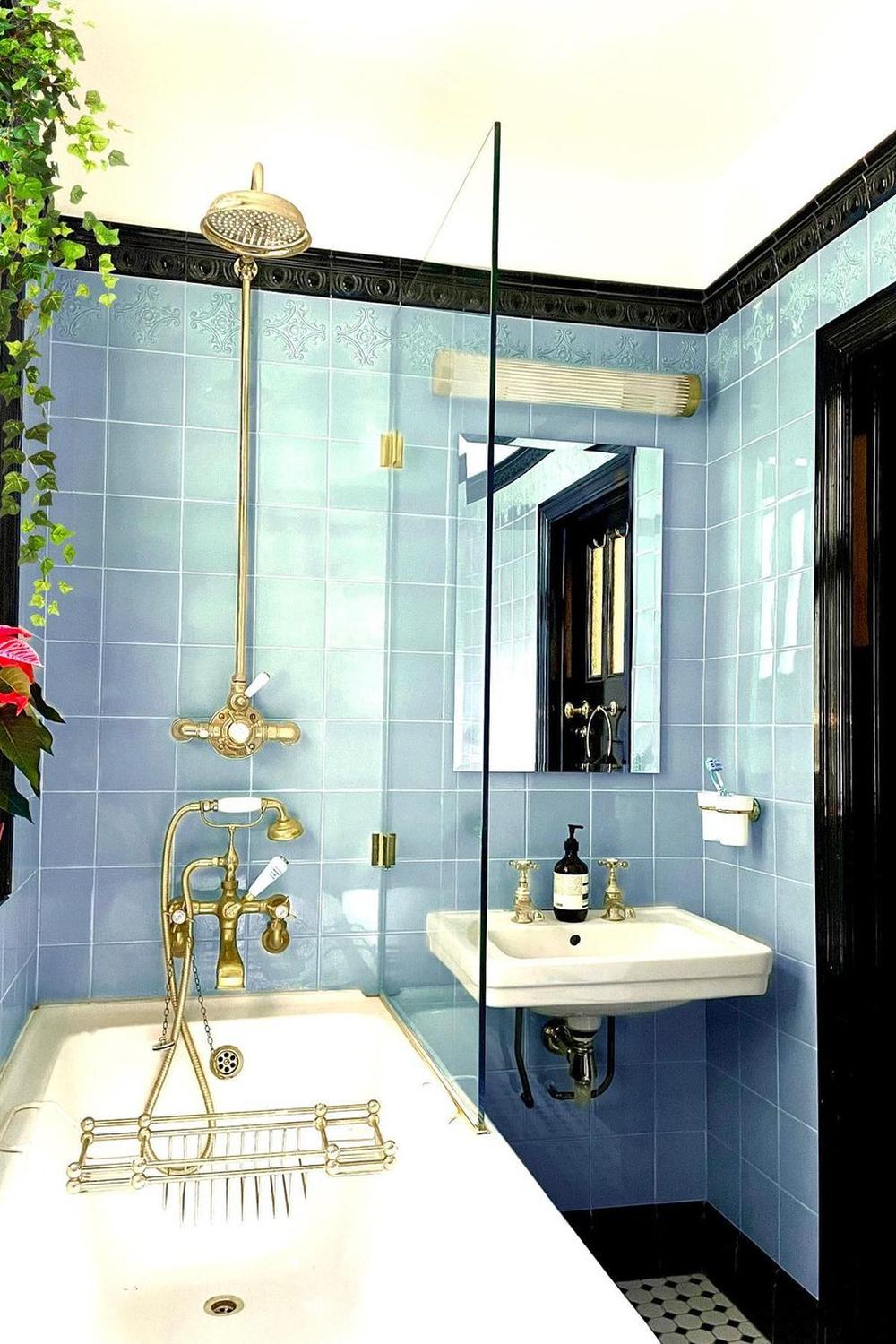 Art Deco bathroom with serene pale blue tiles and vintage fixtures.