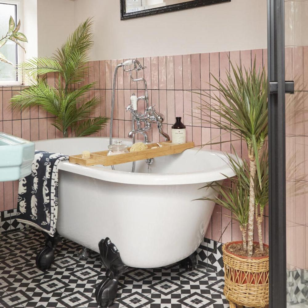 Charming Art Deco bathroom with pink tiles and a vintage bathtub.