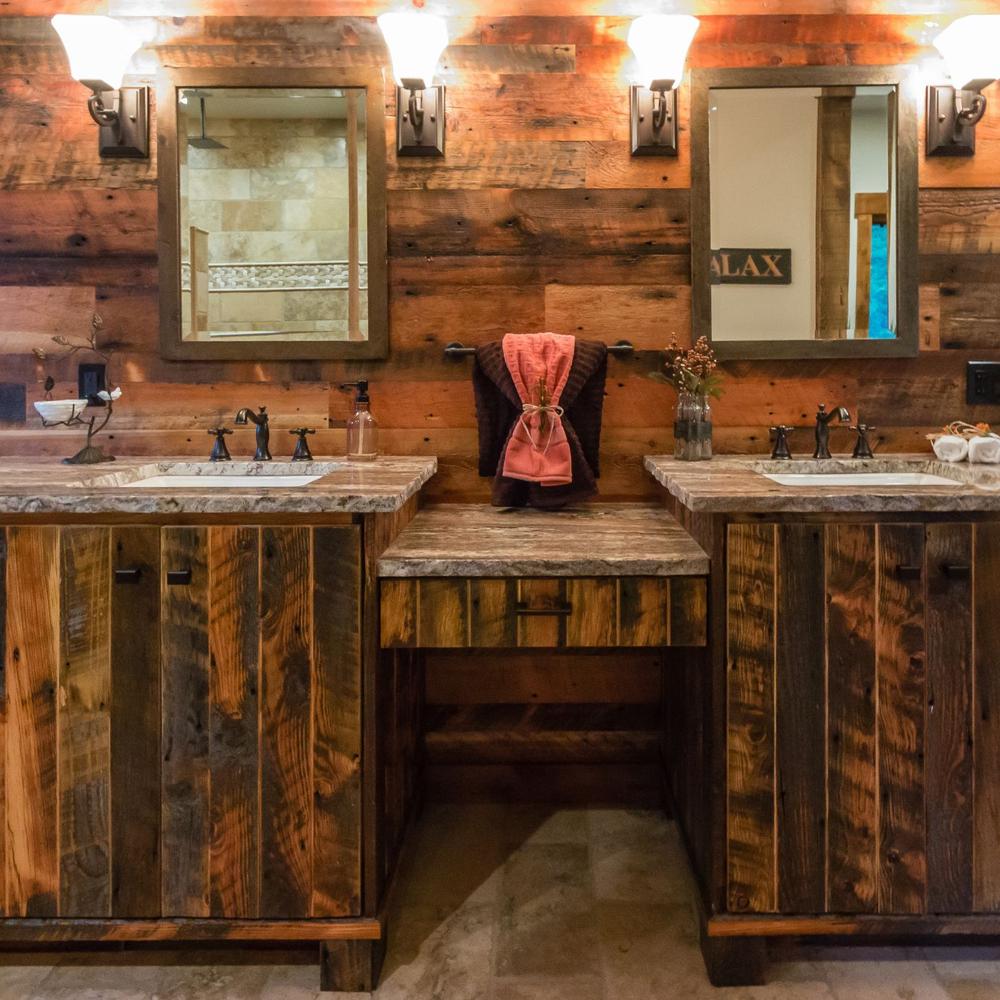 Baño de estilo granero con paredes de madera recuperada y doble lavabo