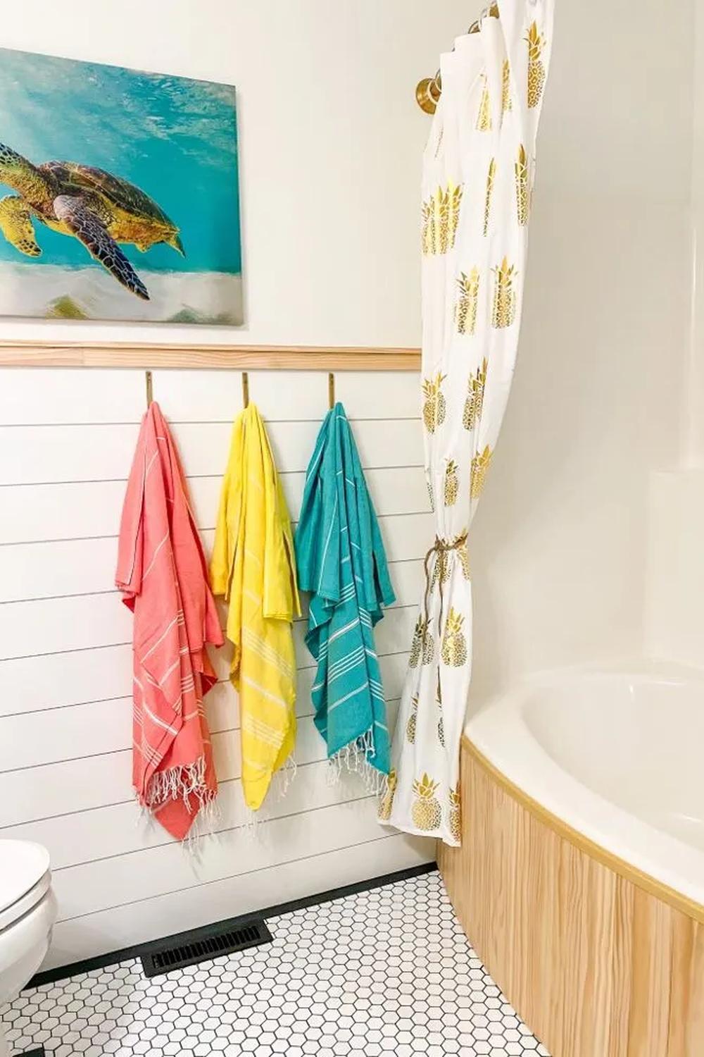 Baño tropical con acento en madera blanca y decoración colorida