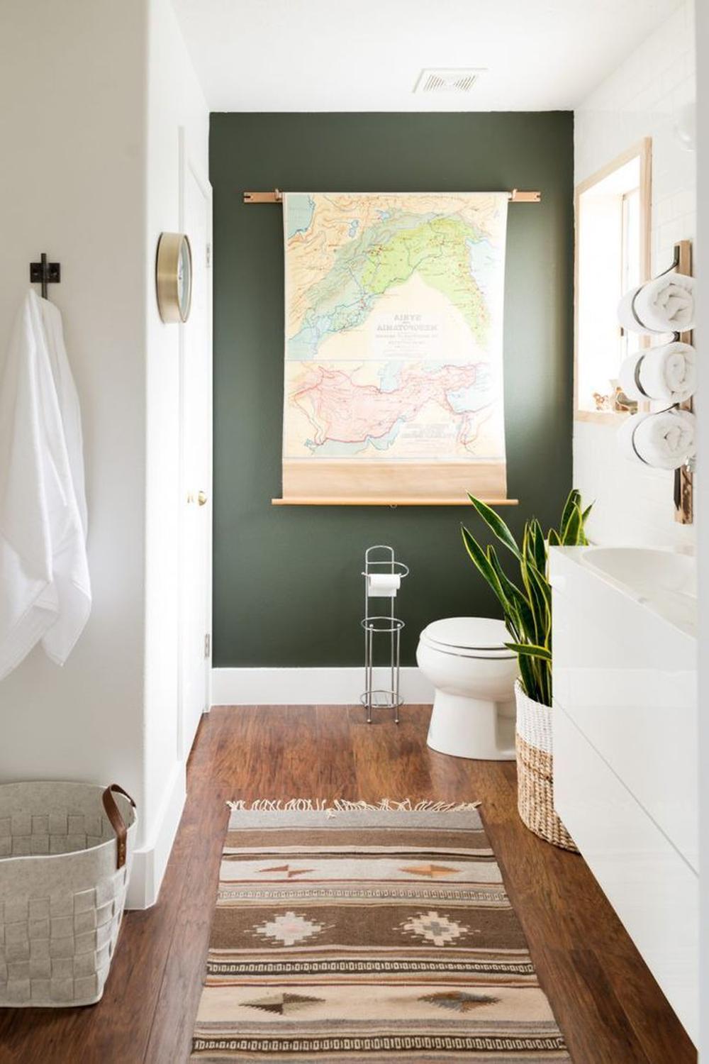 Baño cálido con acento en verde musgo y mapa decorativo