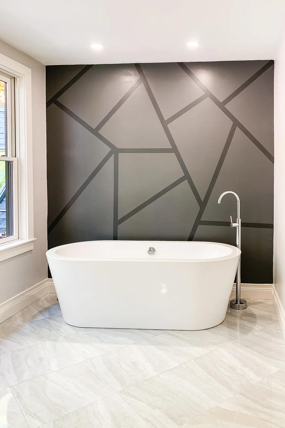 A modern bathroom featuring a bold deep gray accent wall with geometric details for visual interest.
