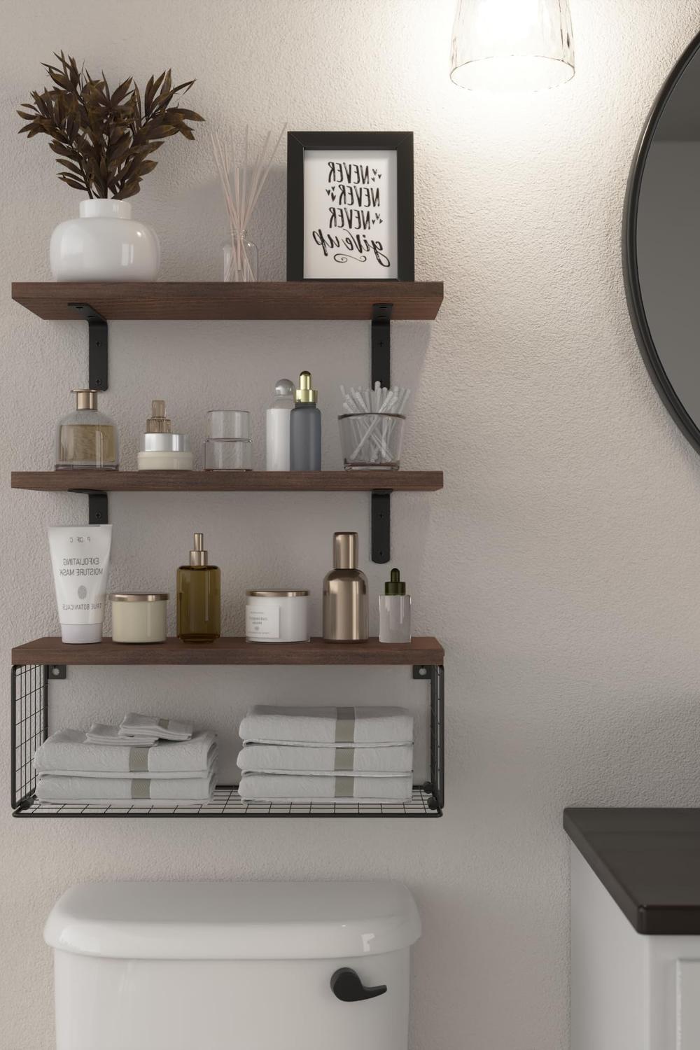 Charming bathroom setup with dark wooden floating shelves displaying motivational quotes and decor above a white toilet.