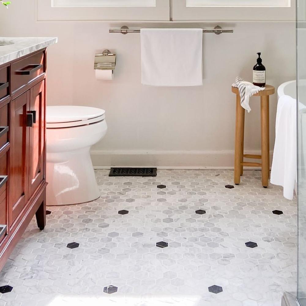 Modern bathroom featuring geometric hexagonal tiles in light gray and white marble with black accents