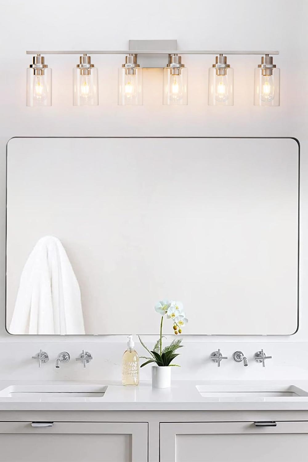 Contemporary bathroom with industrial style elements including a sleek mirror and modern sconces.