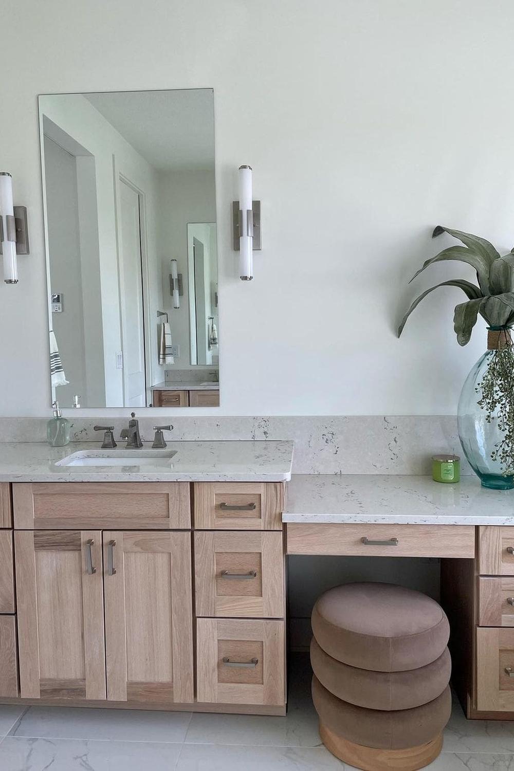 Elegant bathroom featuring a grand oversized mirror and modern sconces.