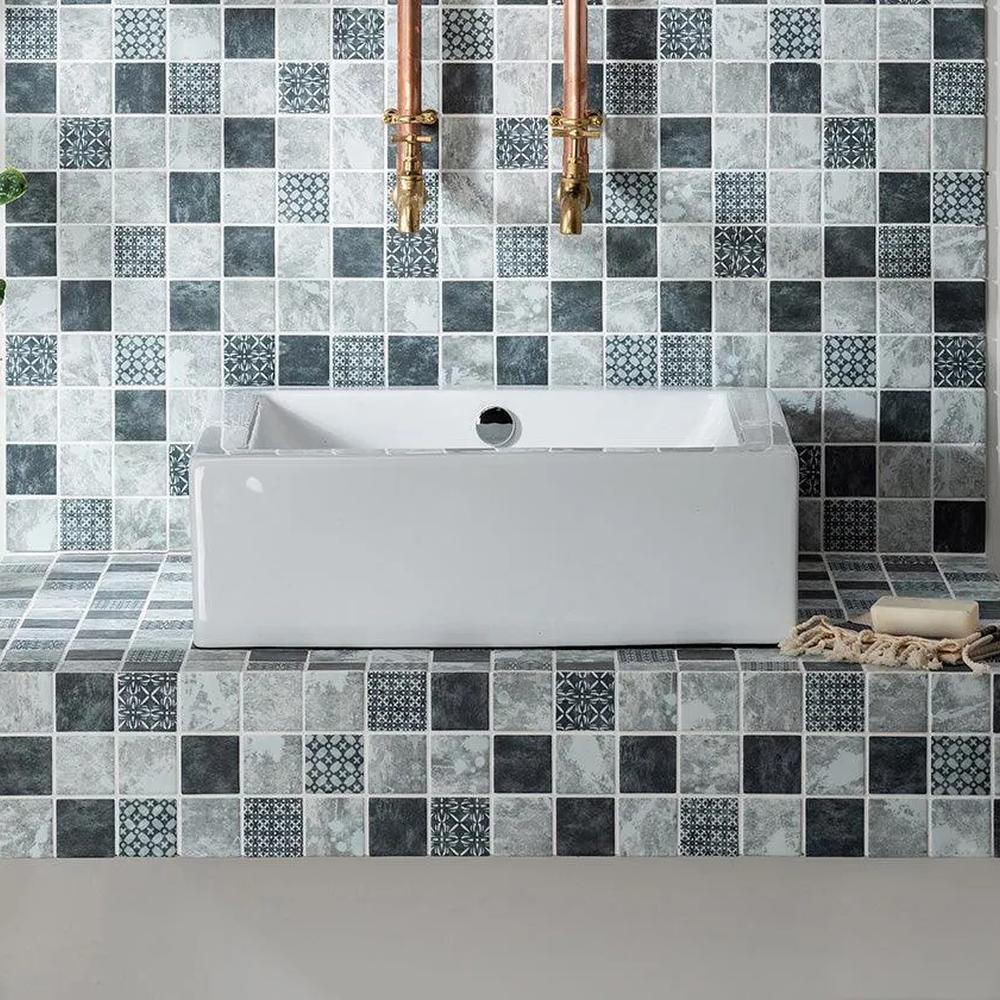 A contemporary bathroom featuring varied gray and white mosaic tiles.