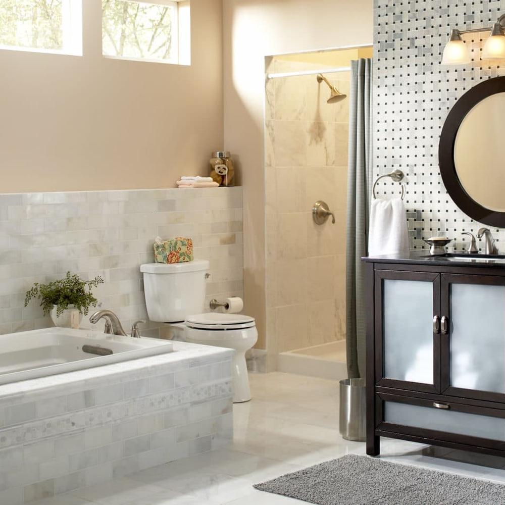 A bathroom showcasing a stylish mosaic tile feature wall with a modern bathtub.