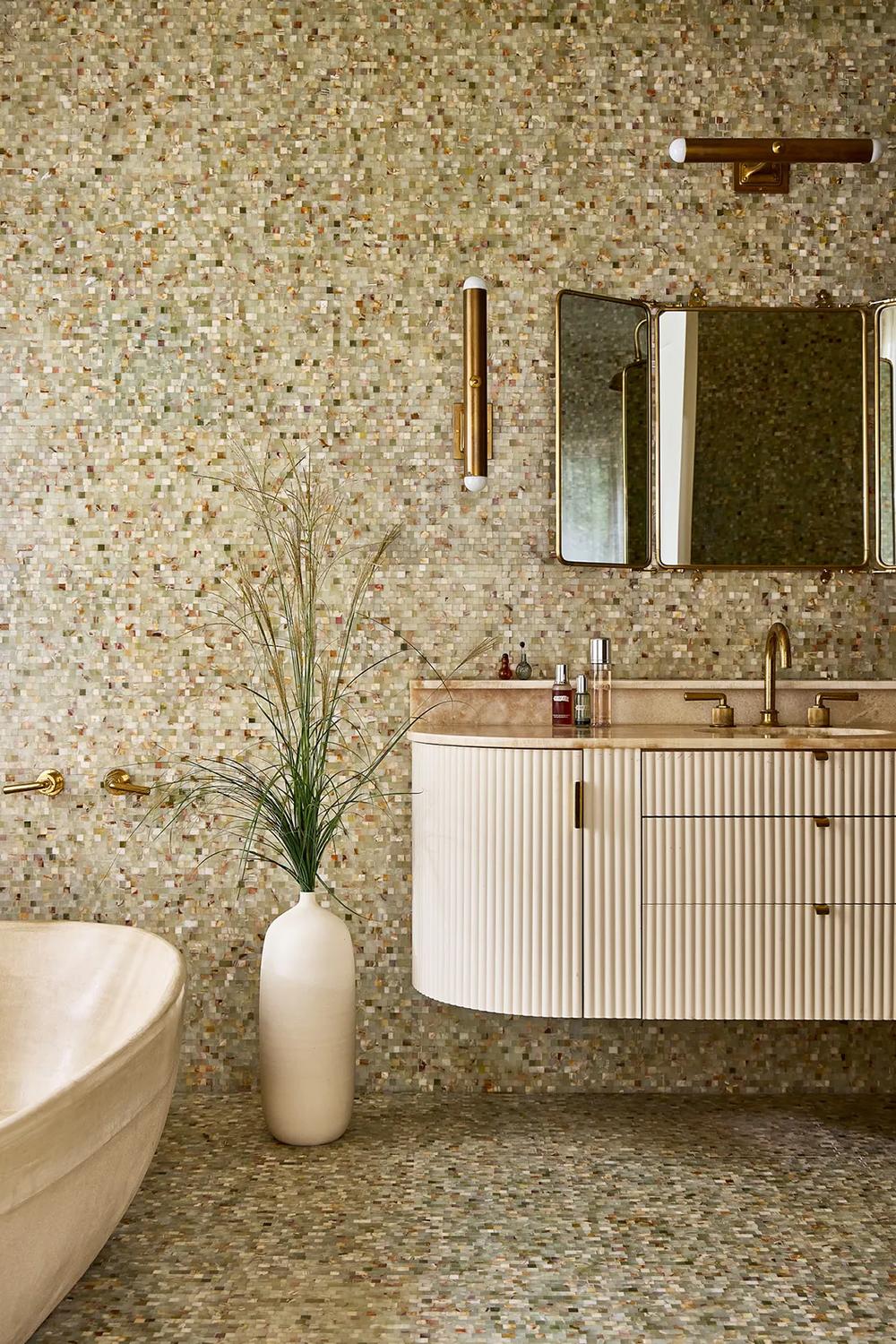 A stylish bathroom featuring a blend of mosaic tiles and natural design elements.