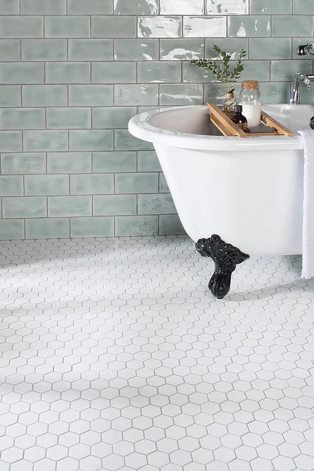 A stylish bathroom with classic mint green subway tiles and a freestanding bathtub.