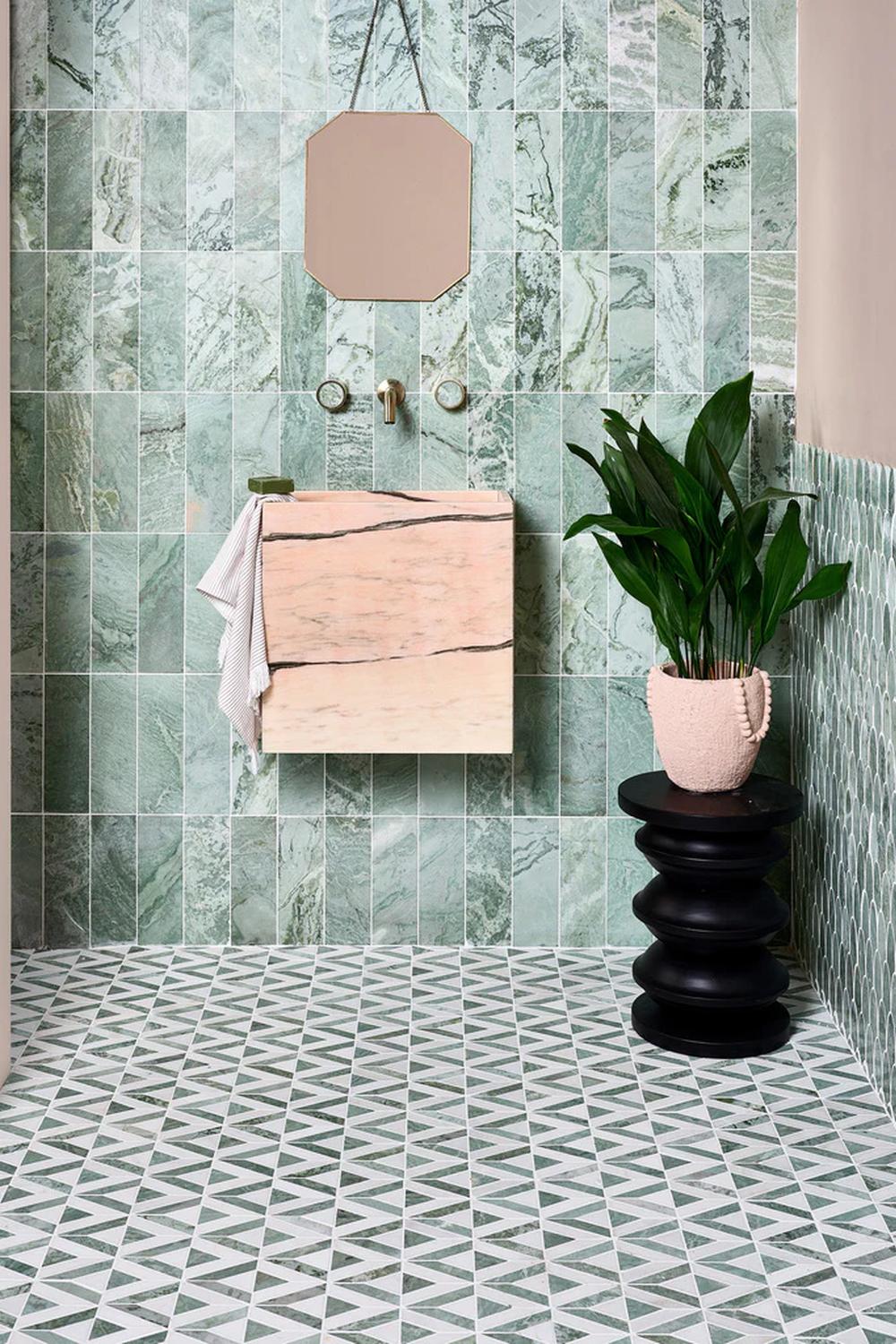 A tranquil bathroom featuring harmonious green tiled walls and geometric designs.