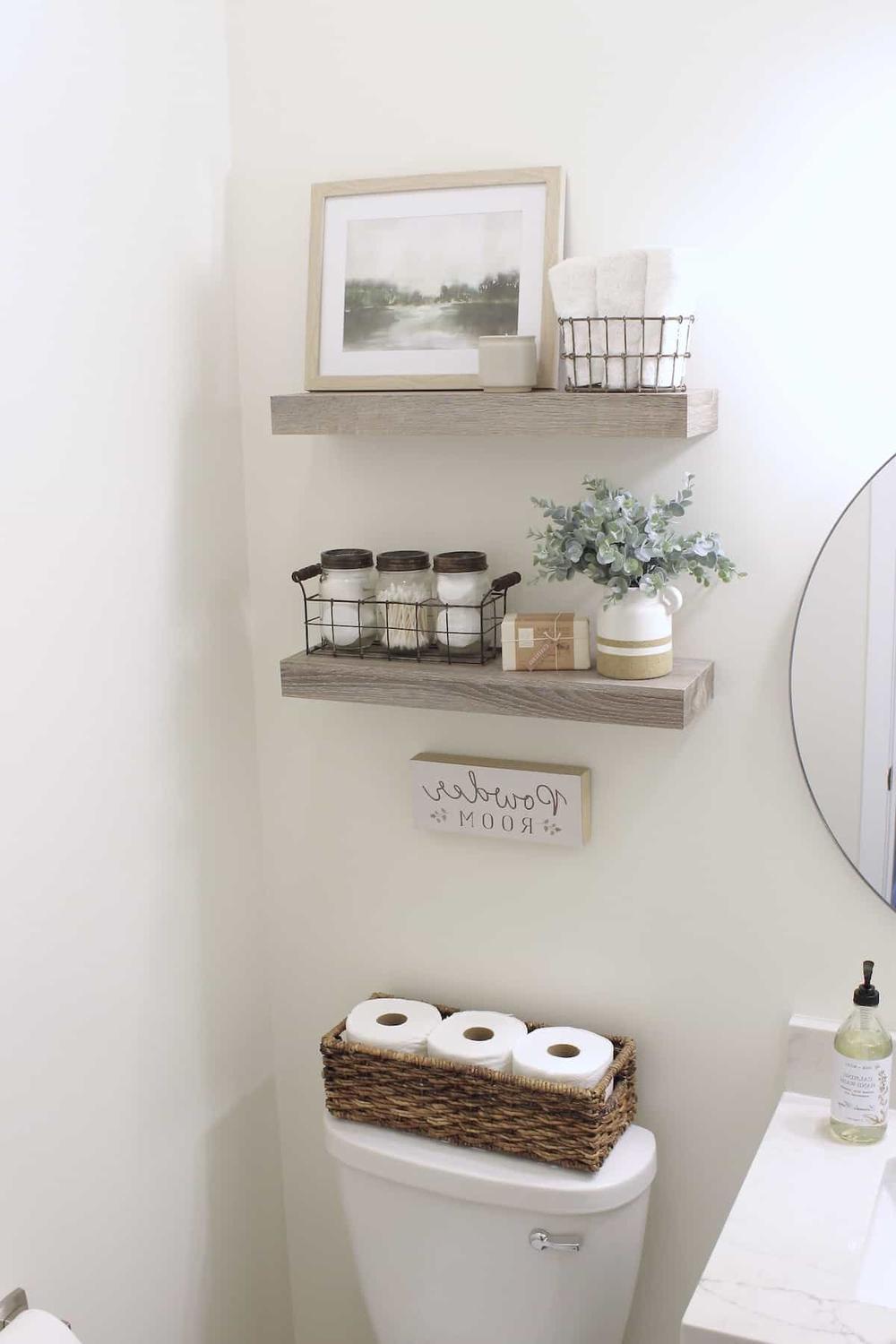 Floating wooden shelves holding decorative items in a bathroom
