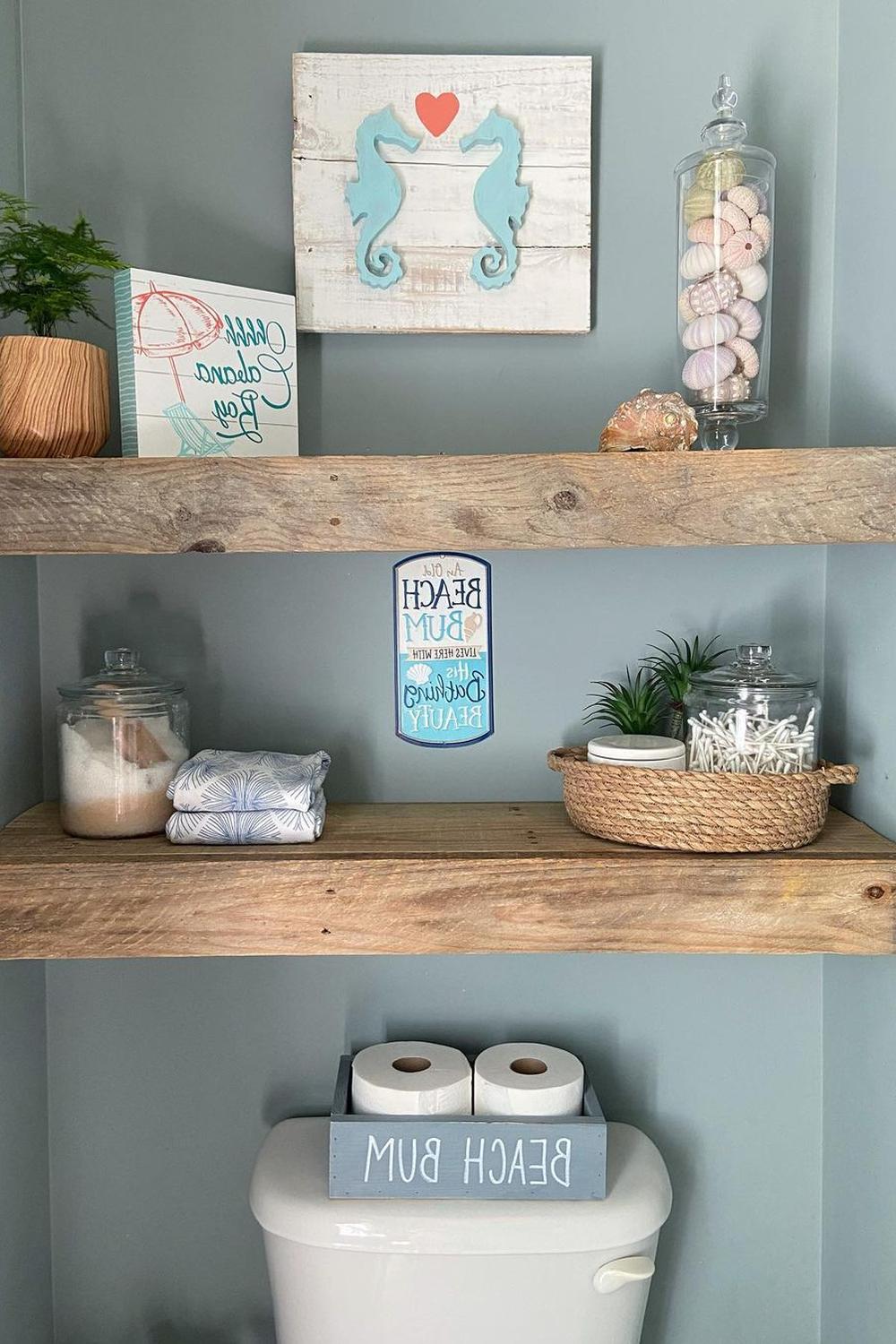 Beach-themed bathroom shelf decor with signs and seashells