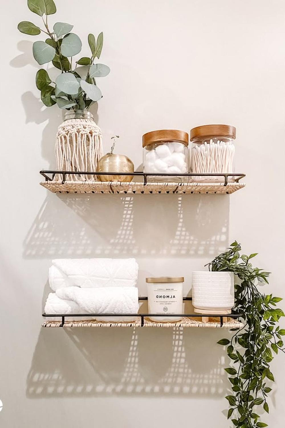 Layered bathroom shelf decor with greenery and towels