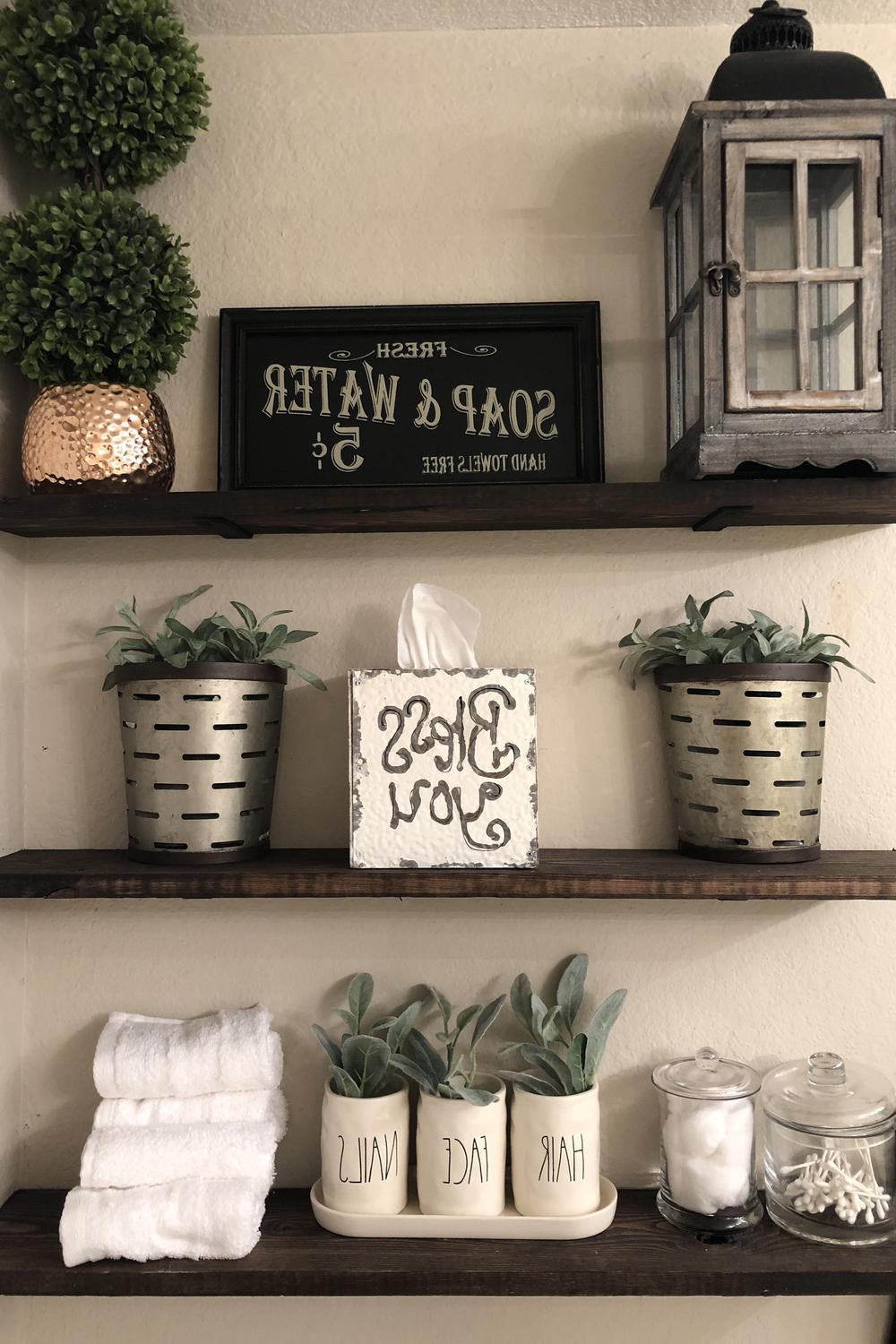 Stylish bathroom shelf with decorative jars and plants
