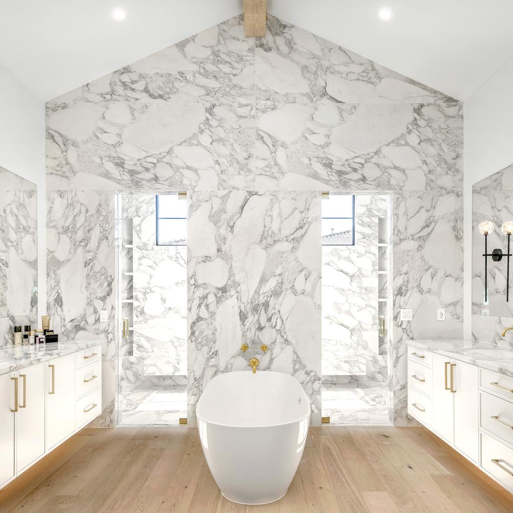 Shower space with expansive marble walls and elegant glass enclosures