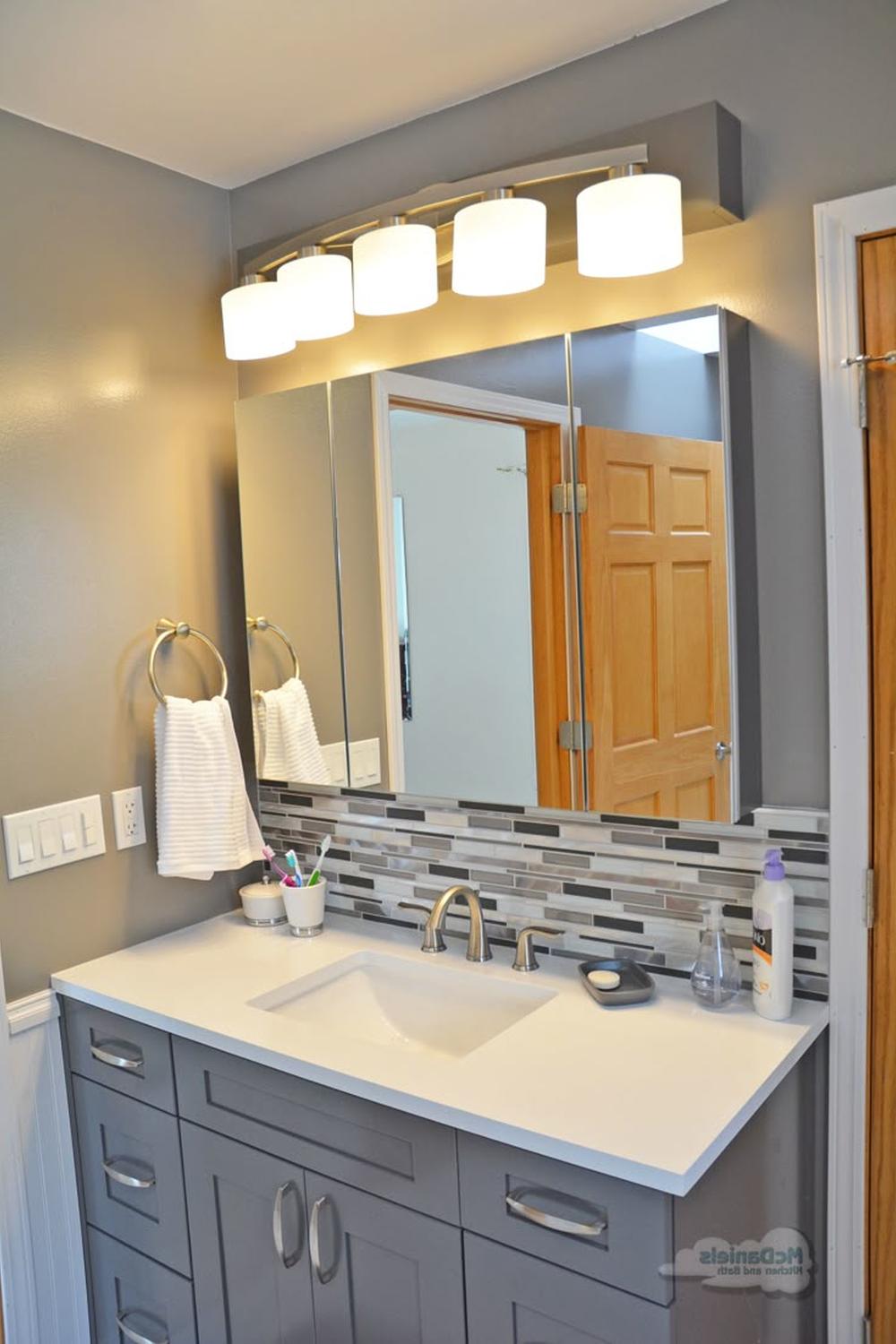 Baño contemporáneo con mueble gris y azulejos contrastantes
