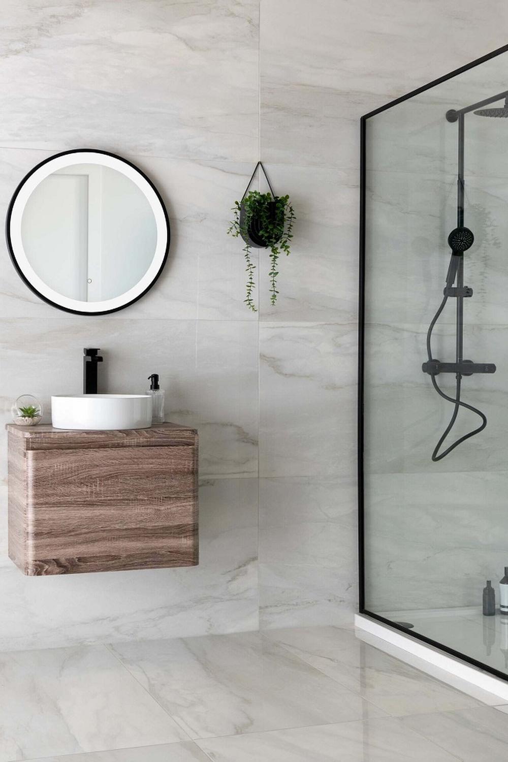 A luxurious bathroom featuring glossy marble-like tiles, a wooden floating vanity, and elegant accessories for a sophisticated allure.