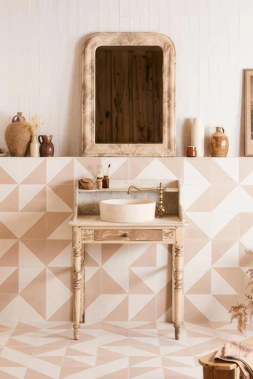 A stylish bathroom showcasing a geometric tiled floor, vintage-inspired vanity, and elegant accents for a warm atmosphere.