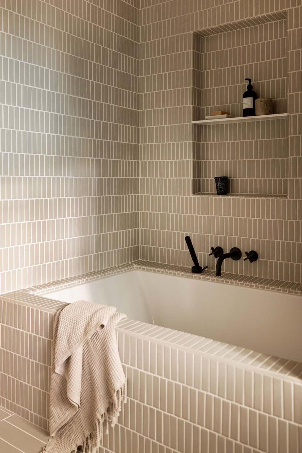 Baño con azulejos beige y diseños elegantes