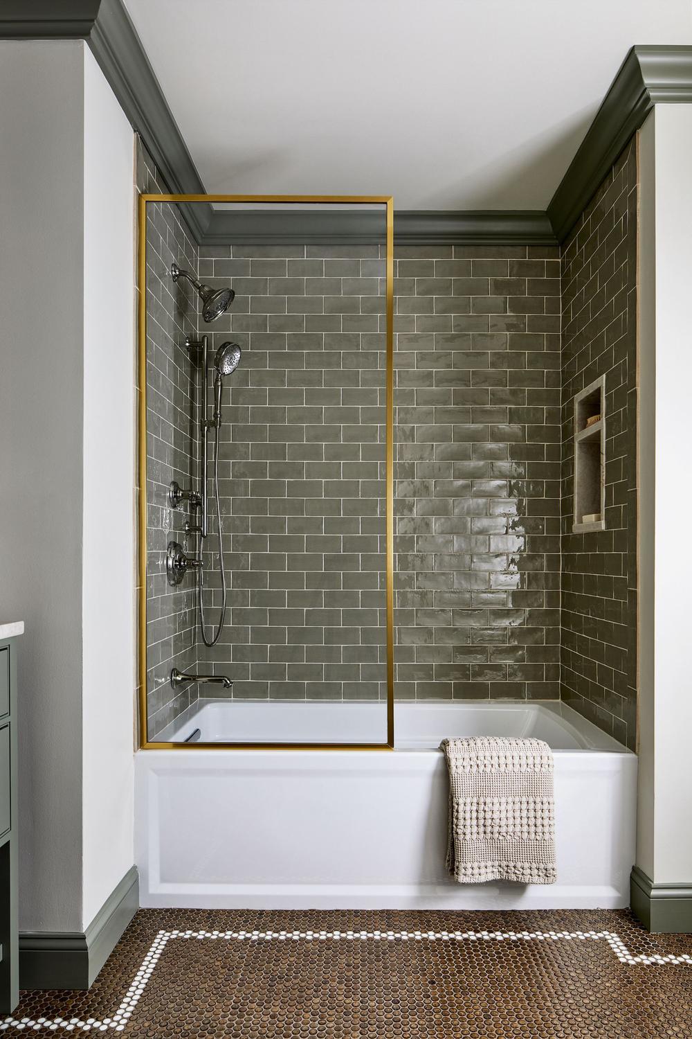 Baño con azulejos oscuros y una atmosfera de lujo