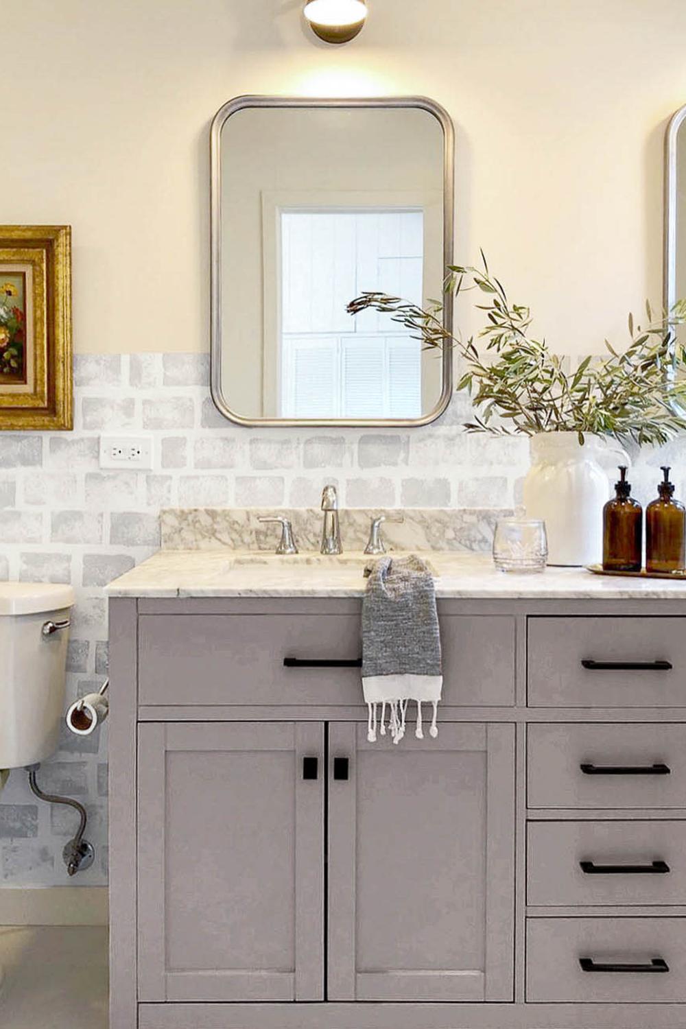 Soft muted gray bathroom vanity featuring a luxurious marble countertop and polished chrome fixtures.