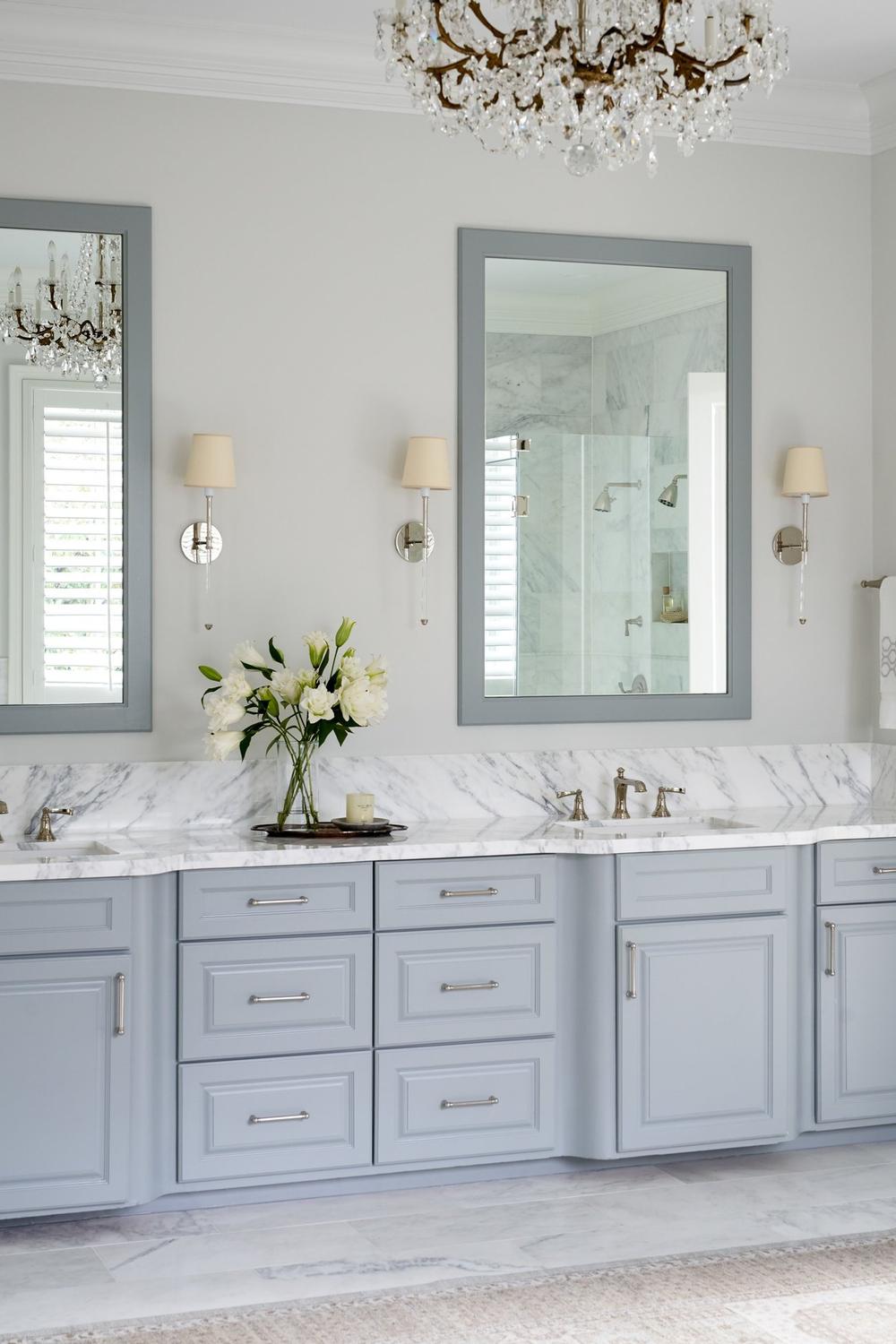 Calm blue-gray bathroom vanity with intricate design elements and a luxurious marble top.