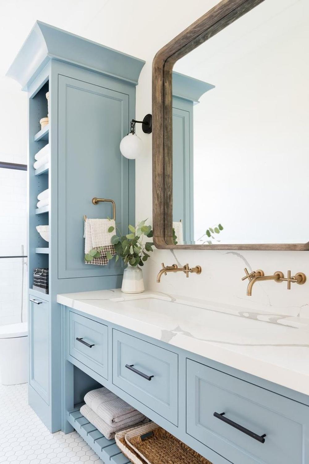Light blue bathroom vanity featuring a rustic wood frame and elegant marble top.