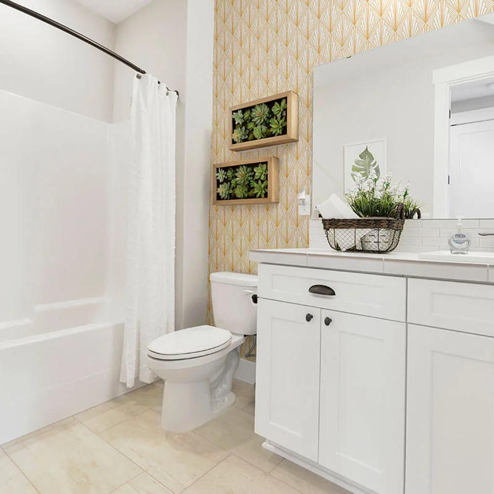 Baño moderno con pared de acento en papel pintado amarillo suave con diseño elegante