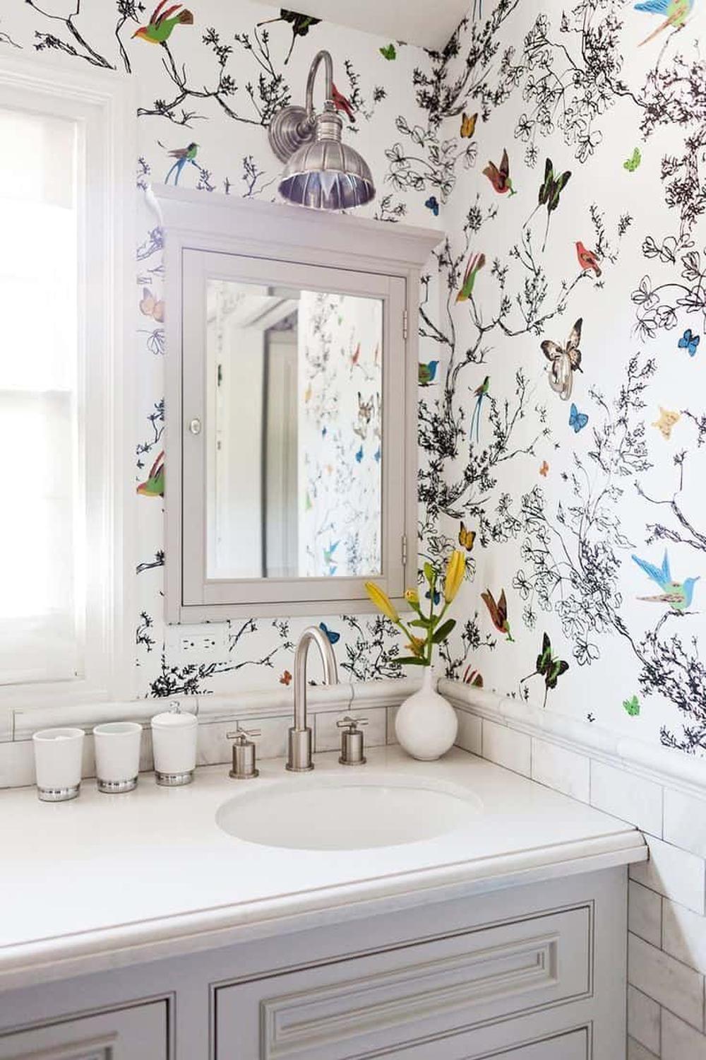 Baño moderno con pared de acento adornada con aves y mariposas en un fondo blanco