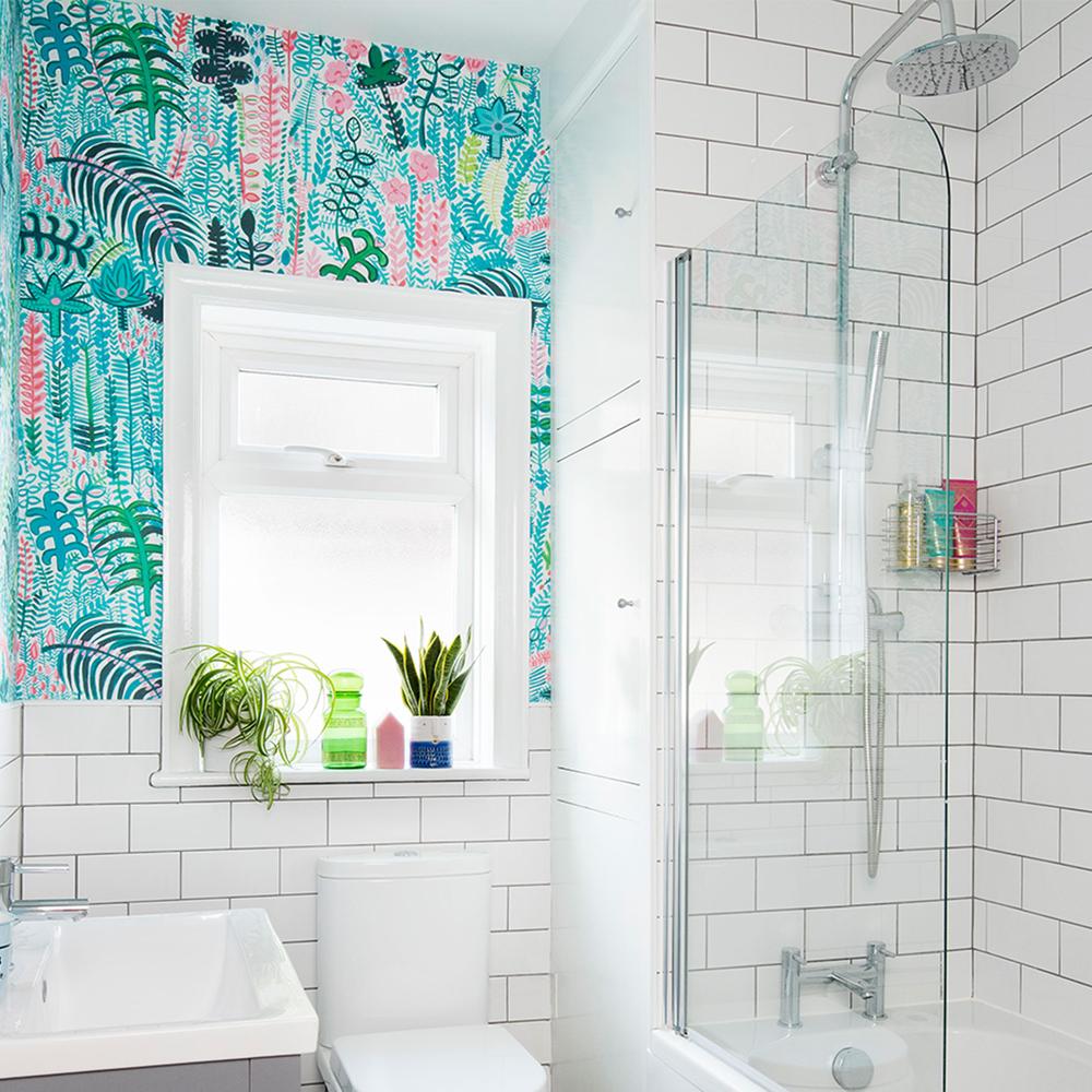 A modern bathroom featuring vibrant tropical wallpaper filled with colorful illustrations of tropical plants and ferns.