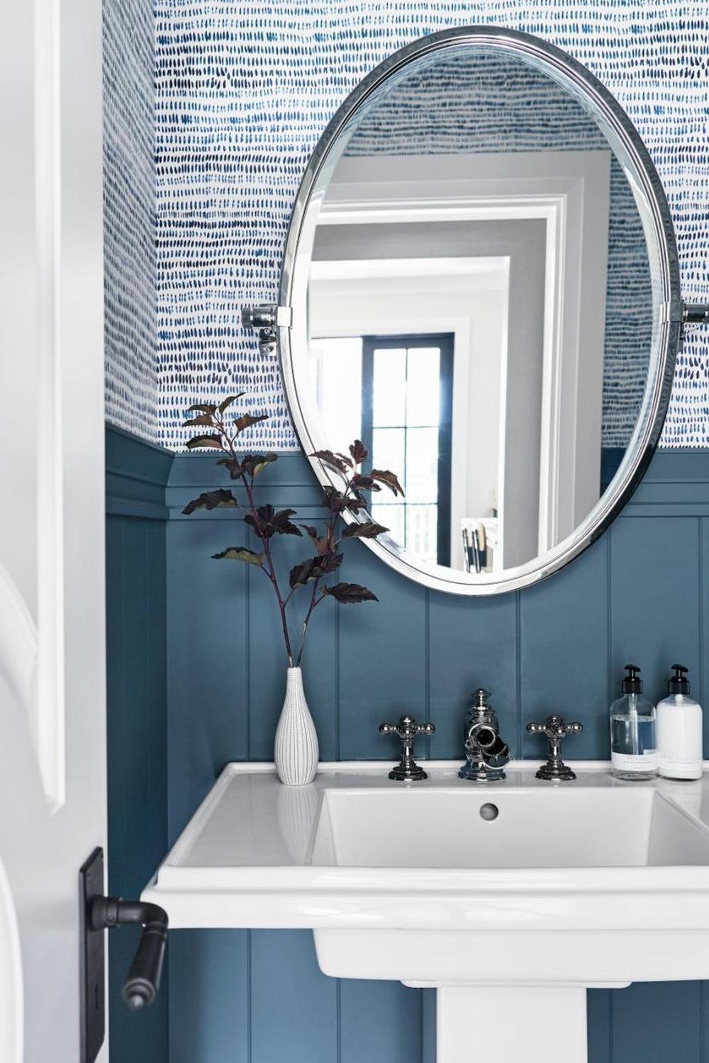 A bathroom showcasing textured wallpaper with horizontal brush strokes in blue and white for added visual interest and depth.