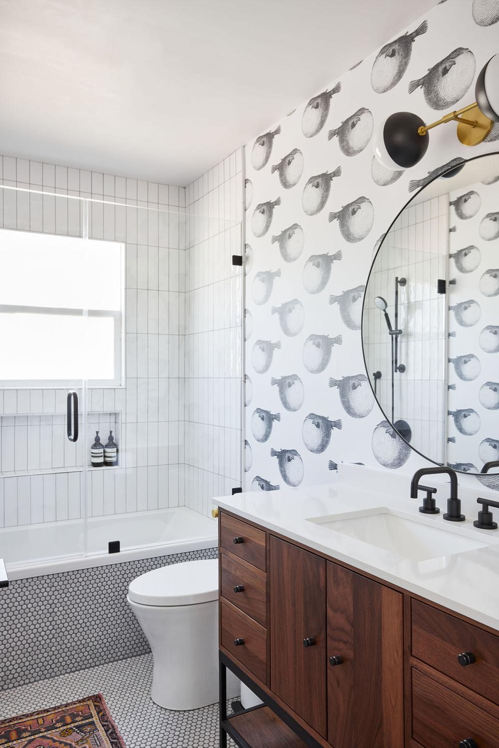 A stylish bathroom featuring whimsical pufferfish wallpaper in black and white.