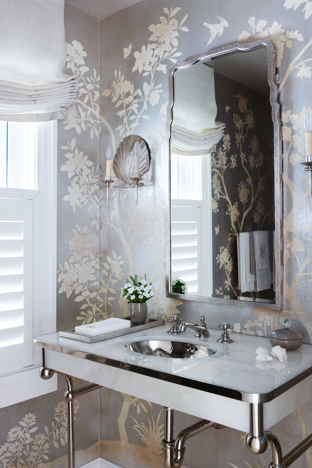 An elegant bathroom featuring soft floral wallpaper with cream and silver tones, combined with modern fixtures.