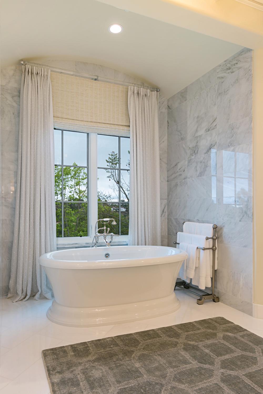 Layered Drapery for Luxurious Complexity - a bathroom featuring layered light drapes and a modern tub.