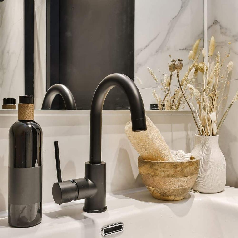 A luxurious bathroom featuring a freestanding black bathtub and minimalist black fixtures.