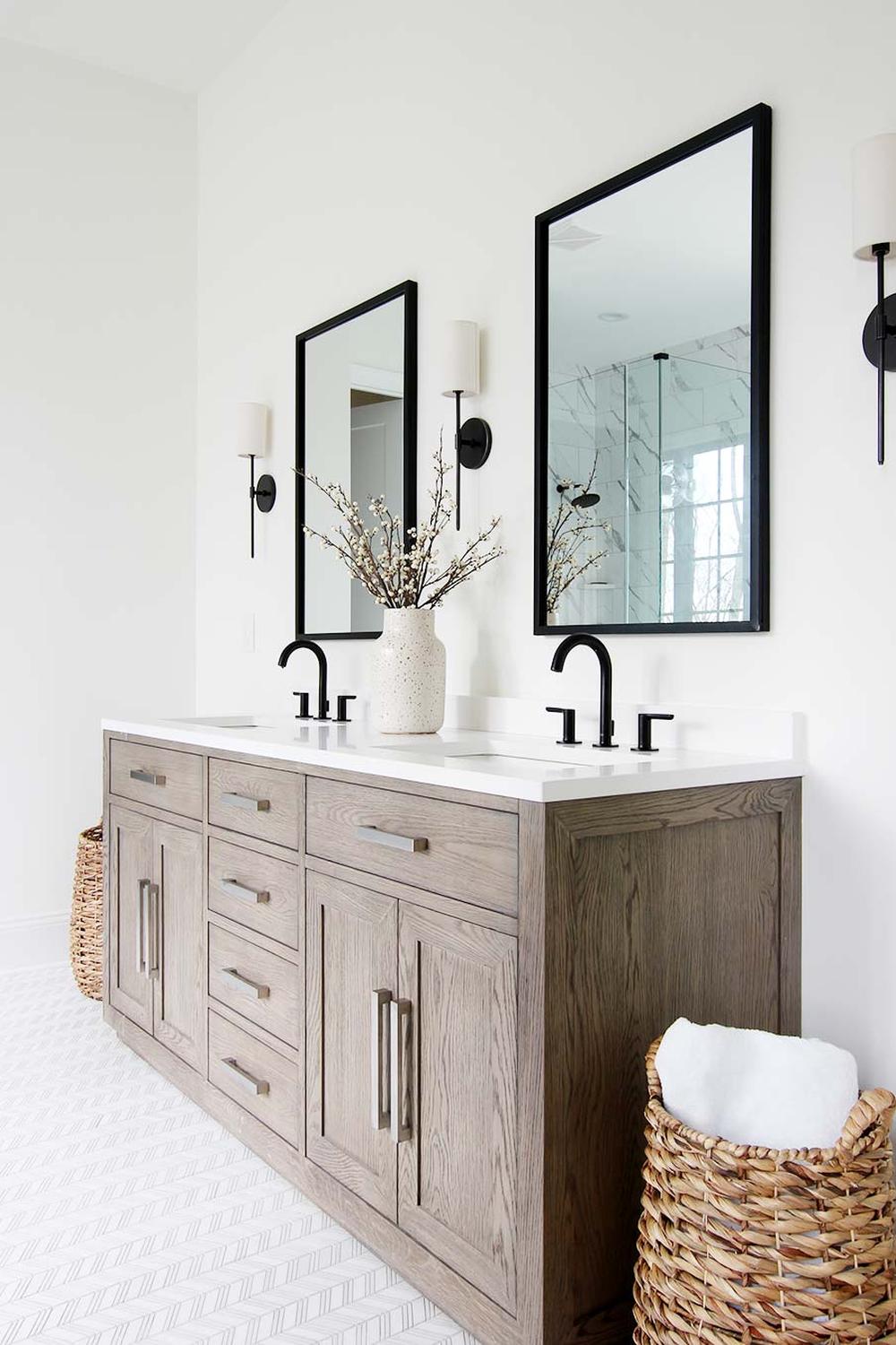 A light and bright bathroom design featuring elegant black fixtures and mirrors.