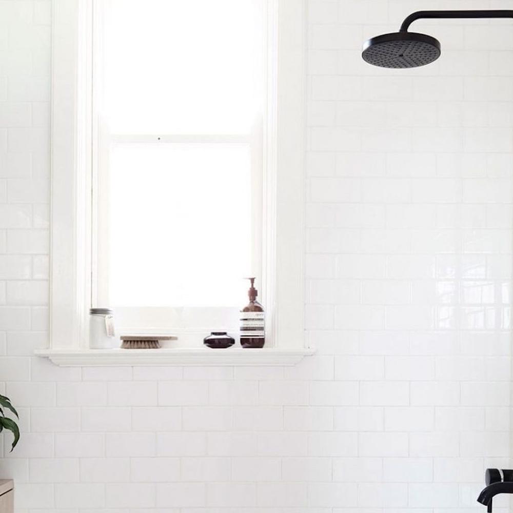 A minimalist bathroom design featuring modern black fixtures and white tiles.